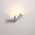 White half cylinder up light wall light fixture on a pale grey background.
